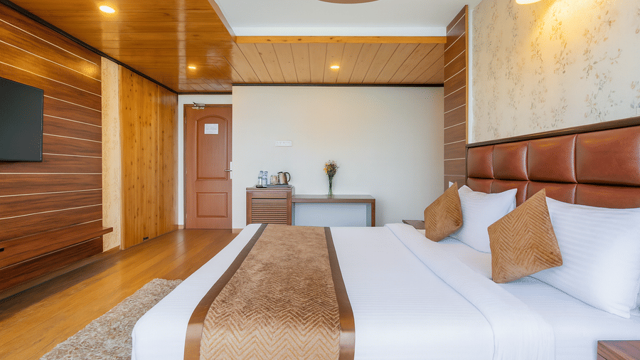 A spacious and well-appointed bedroom with a king size bed at the Yashshree Jai Hotel & Banquet, Darjeeling.