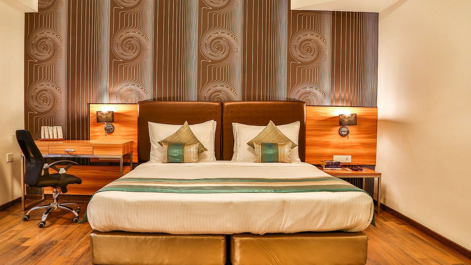 Club Room at T24 Residency, Andheri East (Terminal 2) featuring a double bed in warm lighting with a work desk next to the lamp.