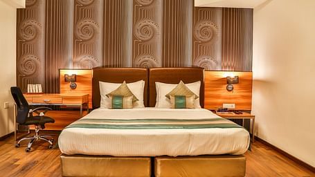 Club Room at T24 Residency, Andheri East (Terminal 2) featuring a double bed in warm lighting with a work desk next to the lamp