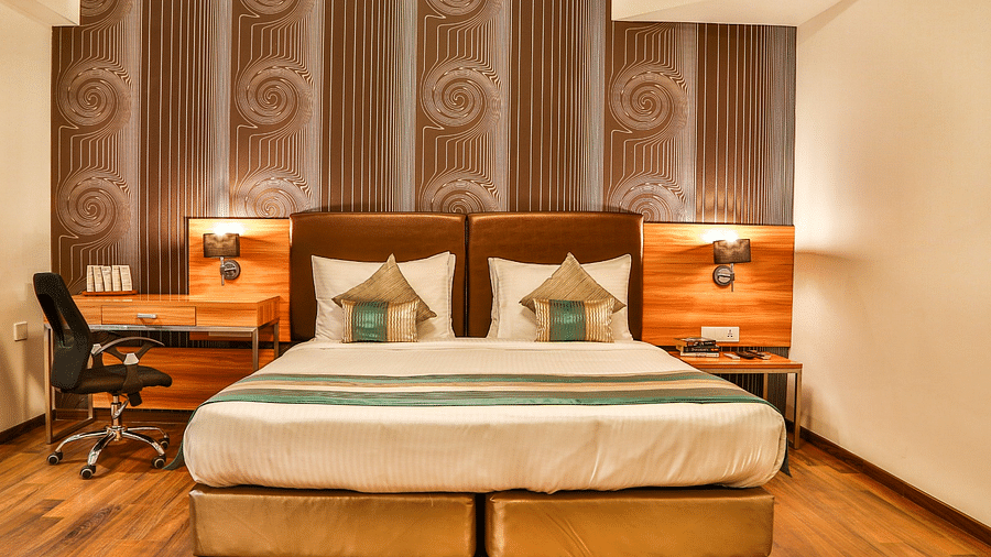 Club Room at T24 Residency, Andheri East (Terminal 2) featuring a double bed in warm lighting with a work desk next to the lamp