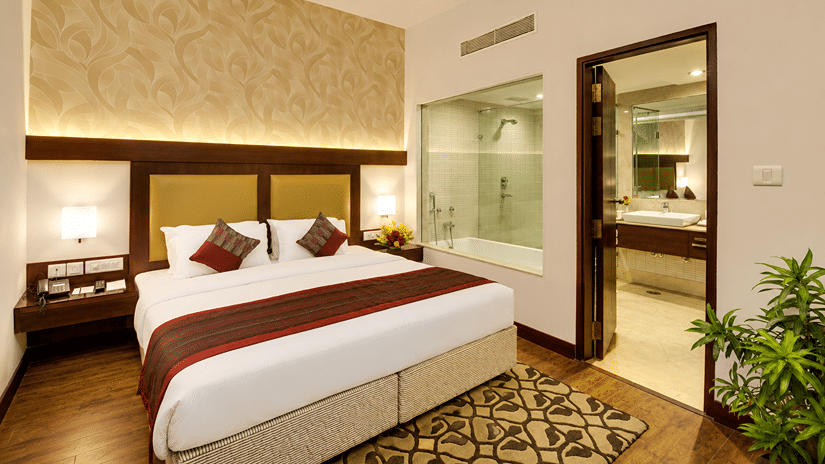Deluxe Suite with king-size bed, bedside tables and attached bathroom.