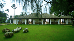green lawn with a bungalow in the background at Parisons Plantation - one of the best Farm Houses in Wayanad