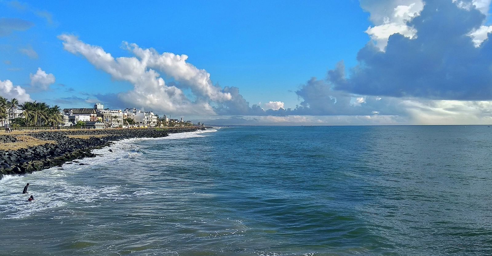 An overview of promenade beach with clouds hovering over the waterbody