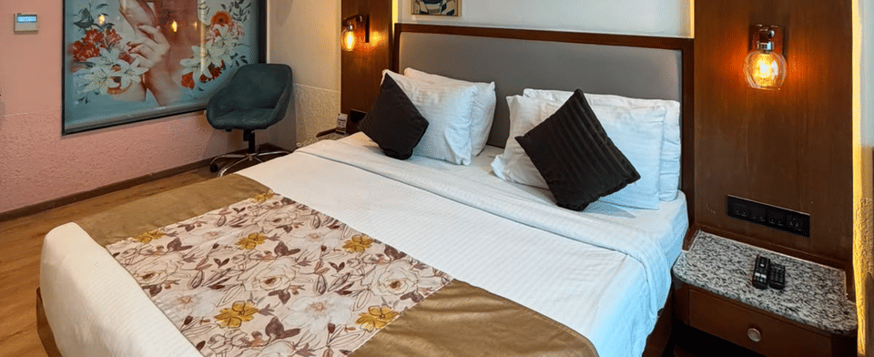 Deluxe Pool Room, Bed with lounge seating and artwork