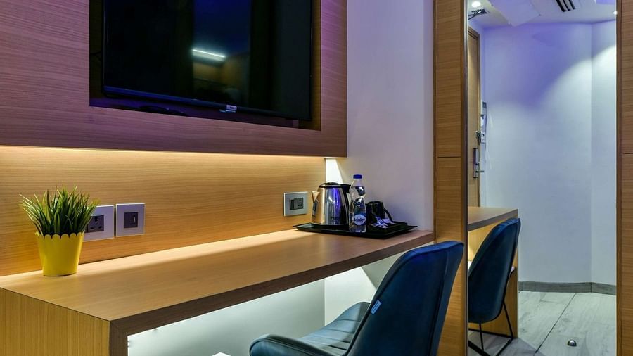 A wooden desk with a pair of chairs and a wall-mounted TV above, at Indie Stays, BKC Kalina.