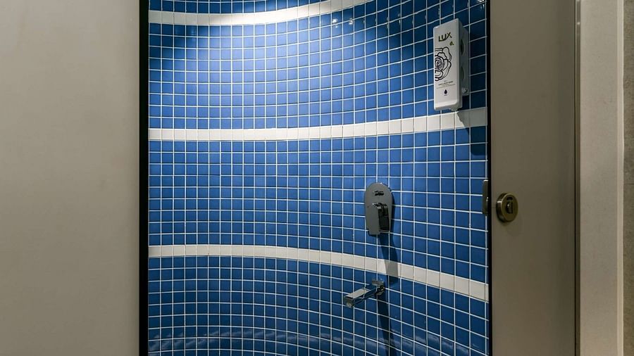 A shower area with a sliding door, illuminated by bright lighting, at Indie Stays, BKC Kalina.