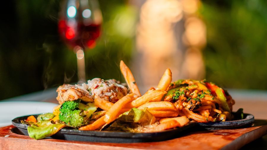 French fries topped with fresh veggies, paired with a glass of red wine at Crescent Spa & Resort, Indore