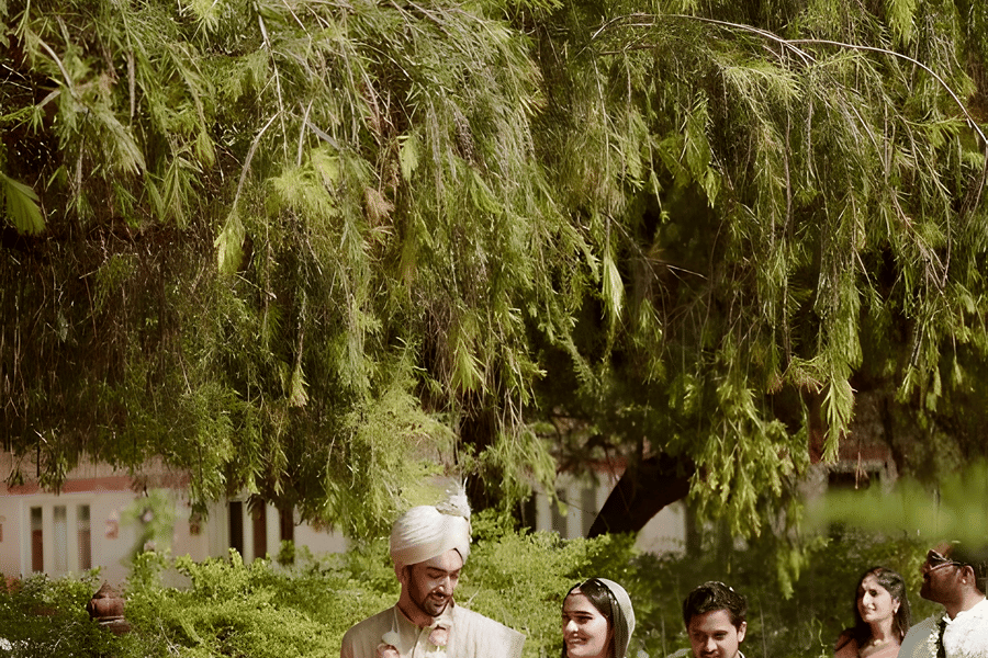 Guest walking through greenery at Umaid Palace during Charvi & Dhruv wedding event.