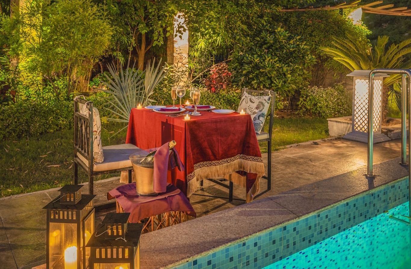 Night view of a swimming pool with a dining table and two chairs set beside it at Valley by Grassfield.
