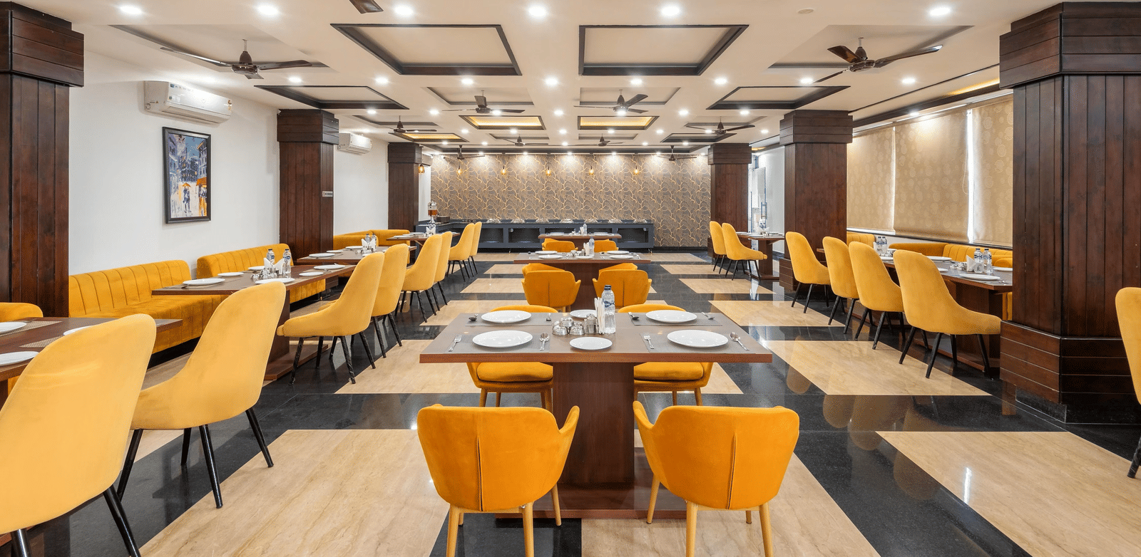 A dining area with many tables, chairs, and ceiling fans at Perfectstayz Premium Shanti Heritage, Haridwar