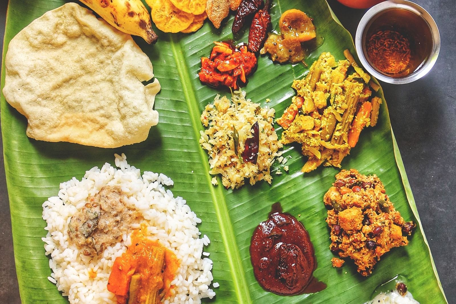 an image of variety of Foods served on a banana leaf