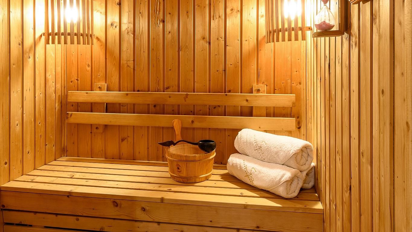 The sauna made out of wood, with warm light and rolled towels - Maikhao Dream Villa Resort & Spa, Phuket