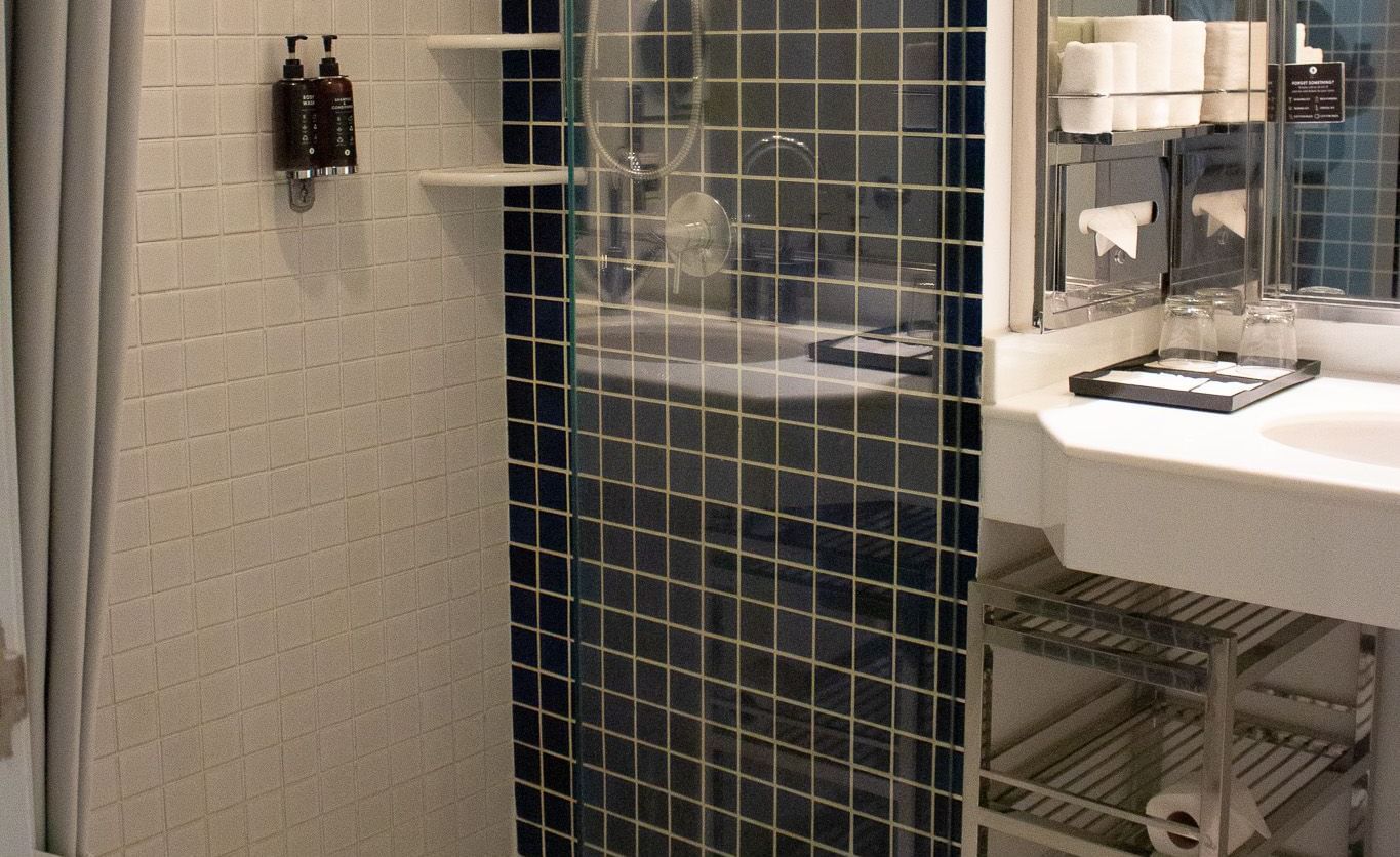 Bathroom at Night Hotel Bangkok with glass shower enclosure and modern fittings.