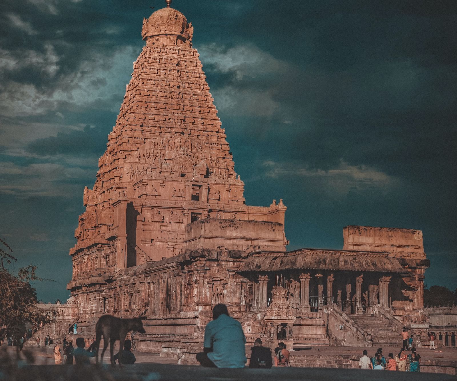 A hindu temple with intricate architecture outside on the roof as seen from a distance