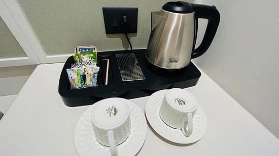 An image showcasing a kettle, cups, plates and packets of tea and coffee - Five Elements Hotels Goldleaf, Haldwani