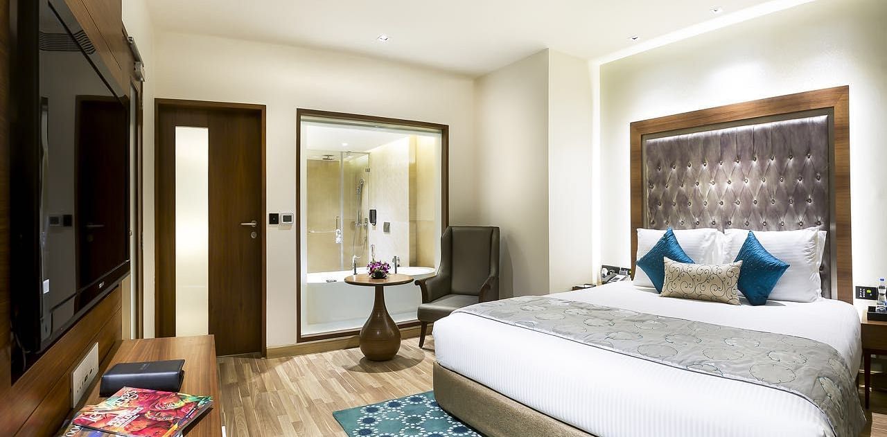 View of the king size bed of a Deluxe Suite at at Grand Chennai By GRT Hotels.