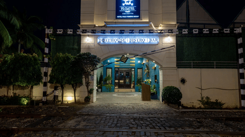 A nighttime view of Floatel's entrance with its sign illuminated and ambient lighting.