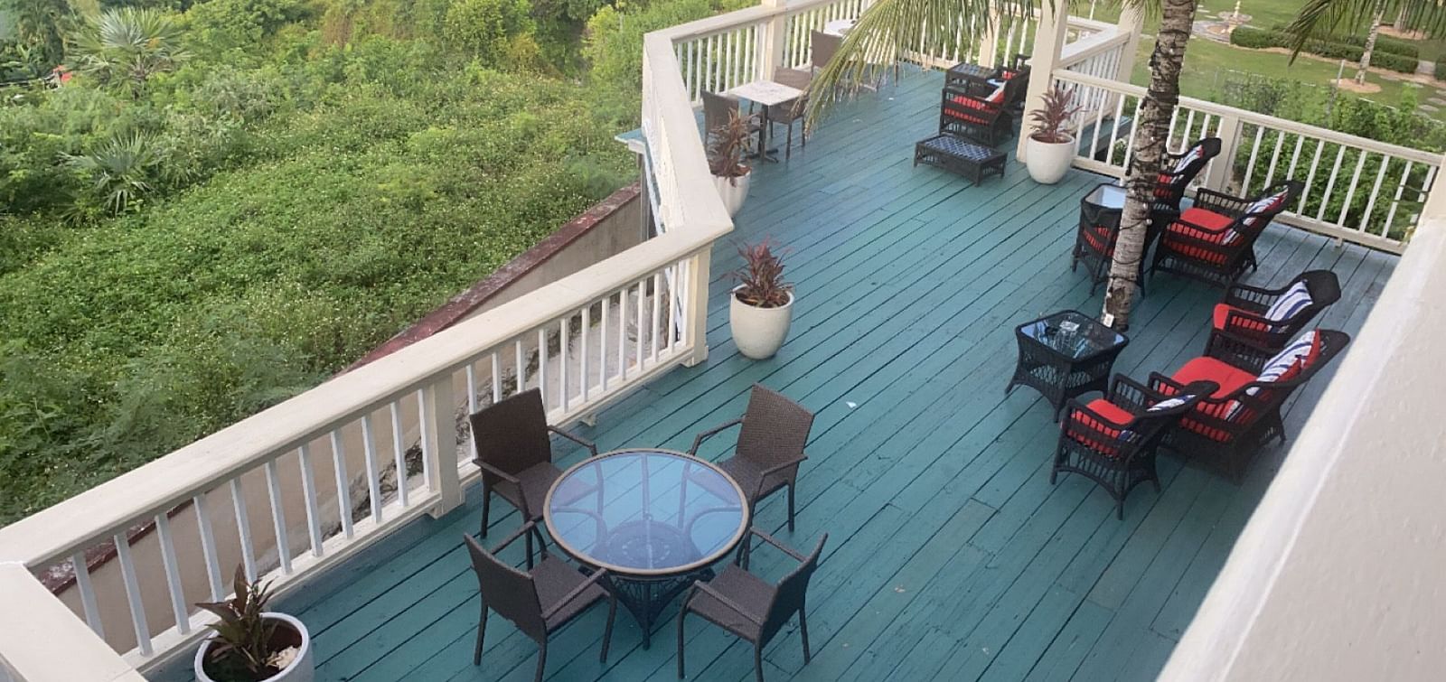 Elevated deck with chairs and tables overlooking lush greenery | A Stone's Throw Away