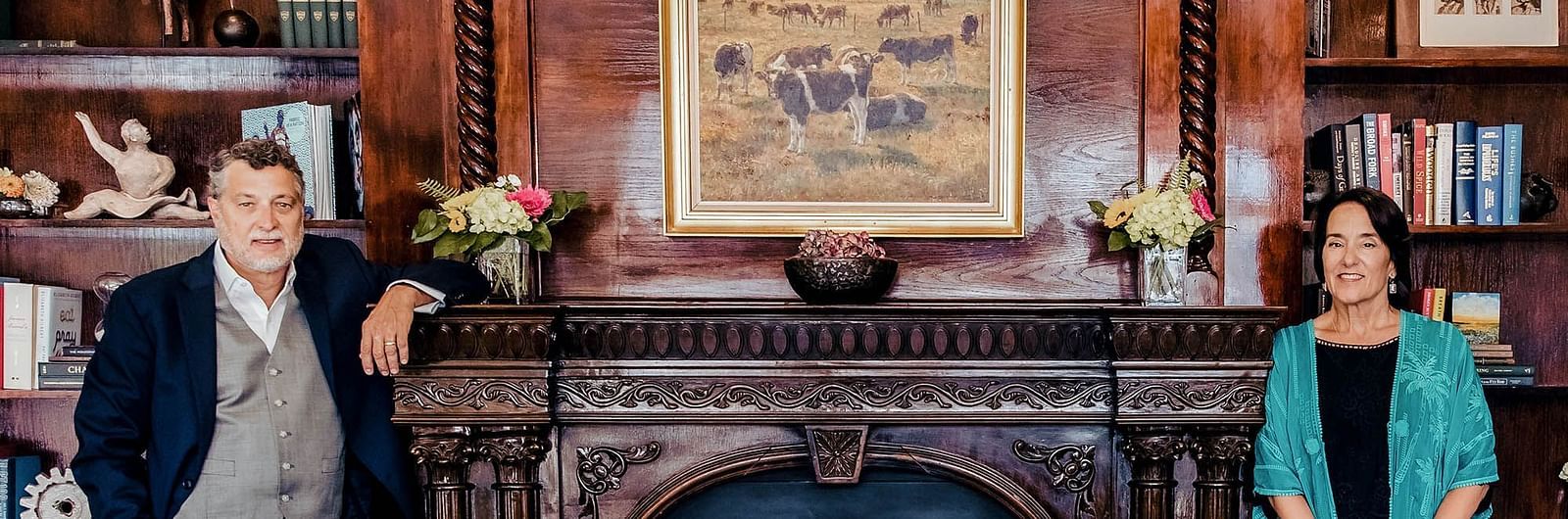A warm and welcoming living room featuring two hosts, a table with drinks, and decorative accents, providing a cosy space for guests - The Grand Hotel & Ballroom, McKinney