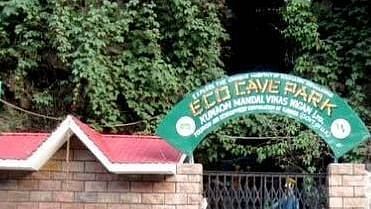 An exterior close up of a cave garden with a sign board and trees around.