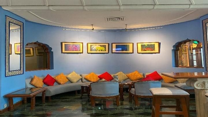 Lounge area with colorful cushions and framed artwork on the walls
