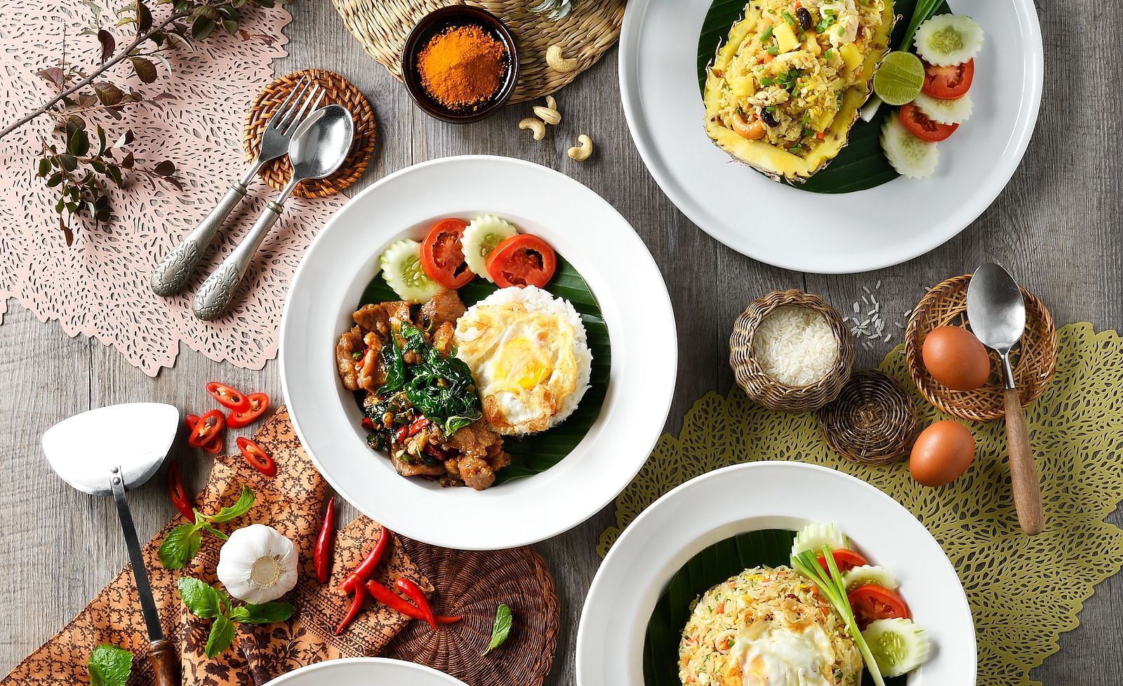An assortment of Thai dishes placed on a table including fried rice