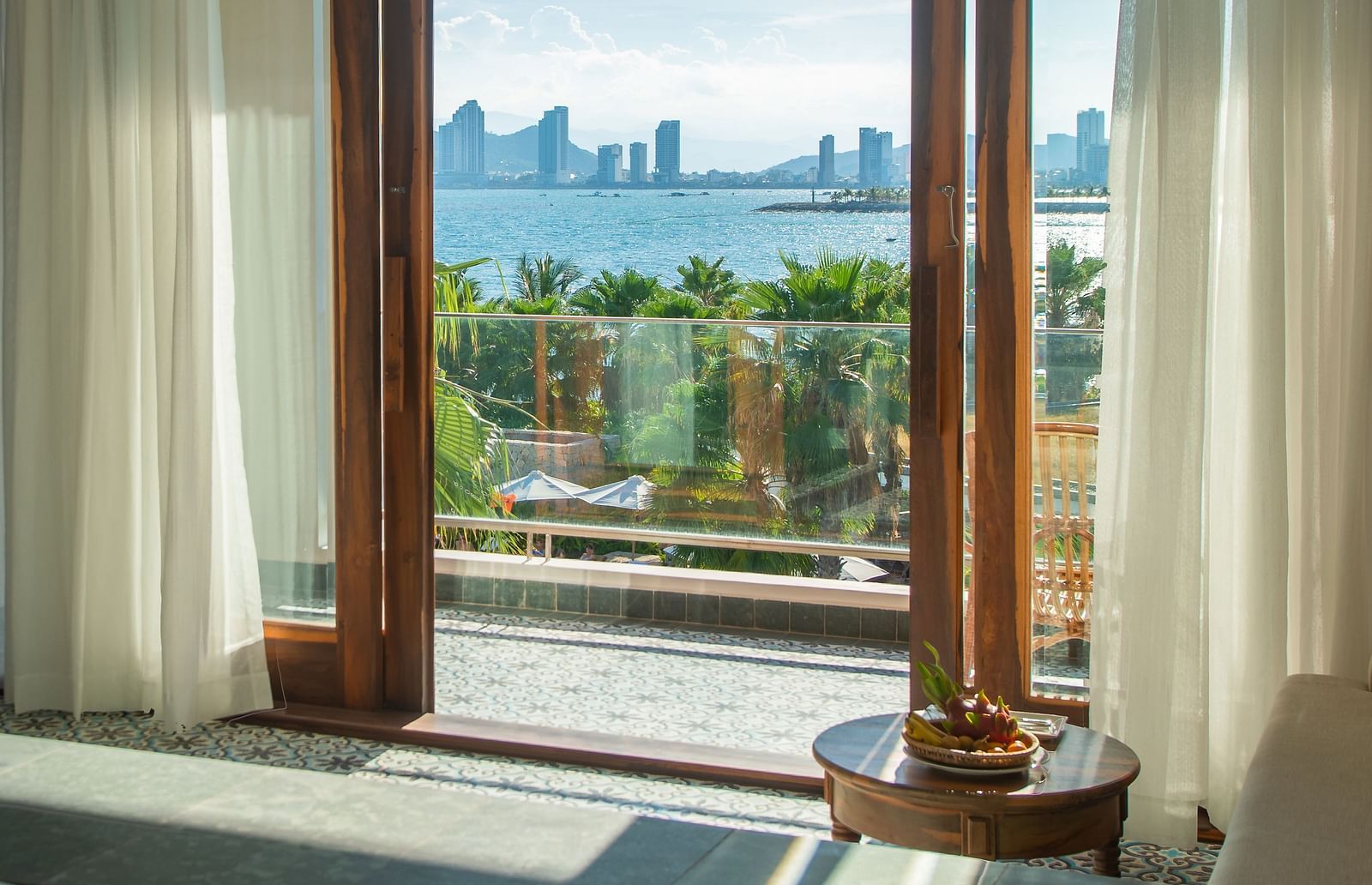 Step onto the balcony through glass doors framed in elegant wood, opening up to a breathtaking view that captivates the senses - Alibu Resort Nha Trang