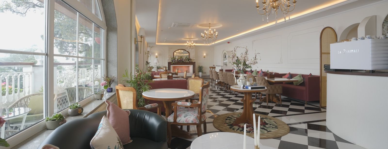 Stylish cafe interior with natural lighting, white tables, and cushioned seating - Mayfair Cafe & Suites, Dalhousie