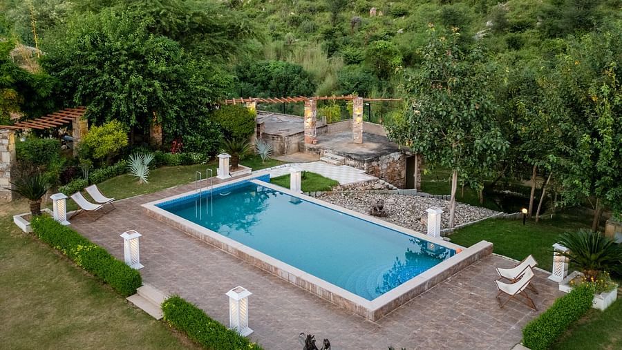 Aerial view of a swimming pool with plants and trees around it at Valley by Grassfield.