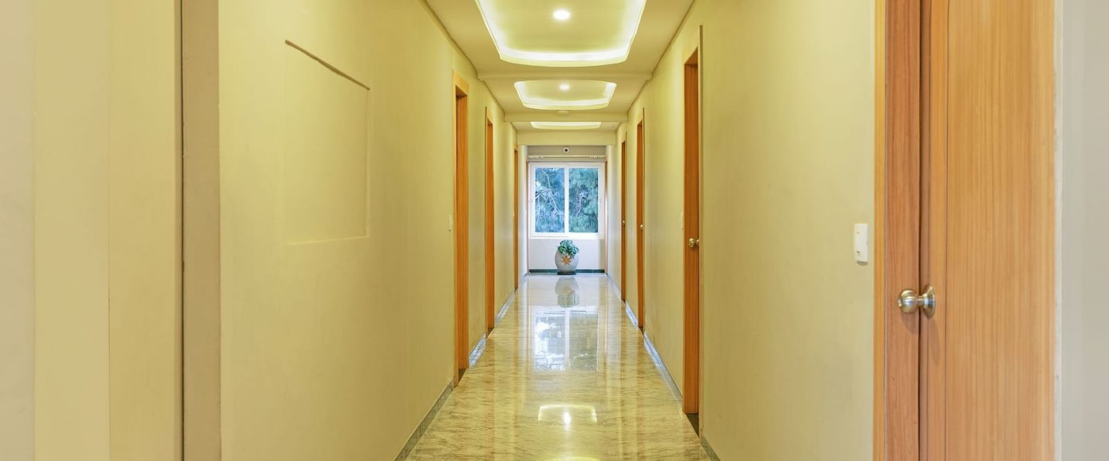 Long corridor in a modern building with marble floors and ceiling lights | Mango HIll Central, Ooty