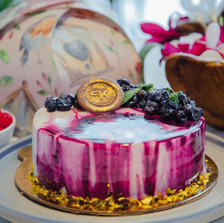 A close up shot of a table with a cake kept on it - Karma Lakelands.