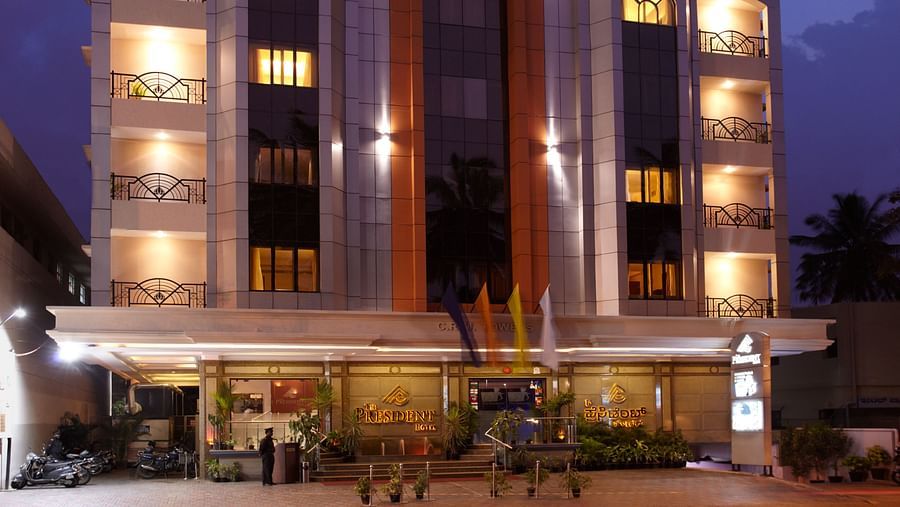 A tilted  facade view of The President Hotel Jayanagar, Bangalore during night time.