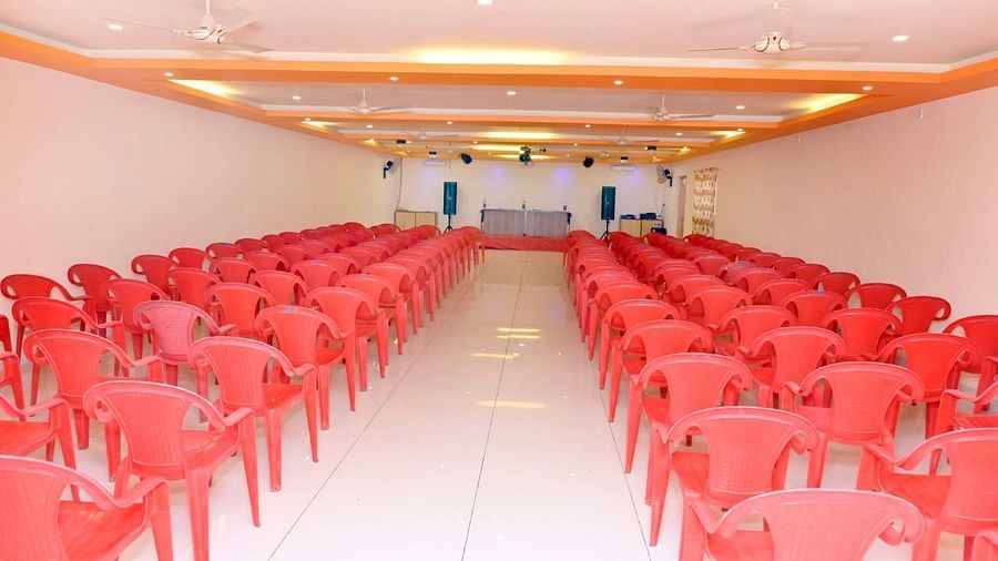 An image of the seating arrangement at the banquet hall  with a table and chairs placed on a podium at Nisarga Lake Resort
