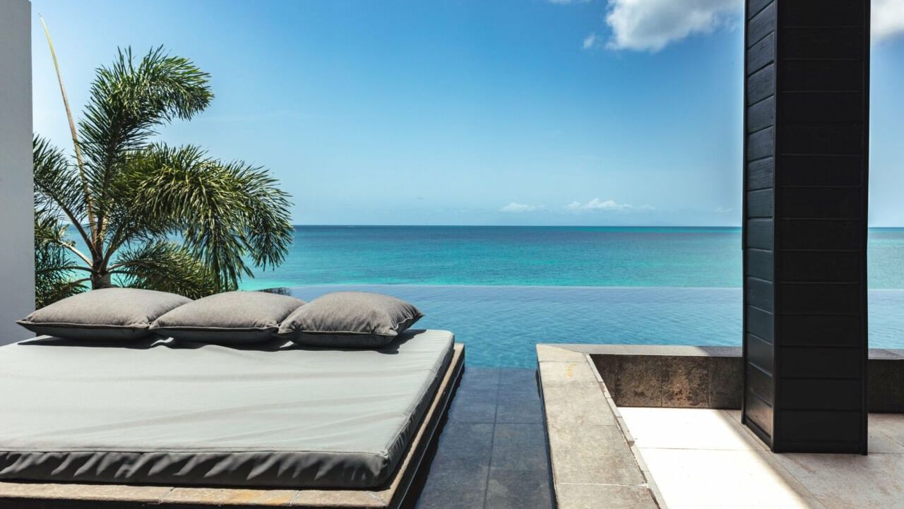 Sunbeds by a private pool with endless sea views at Tamarind Hills Antigua – Resort & Villas