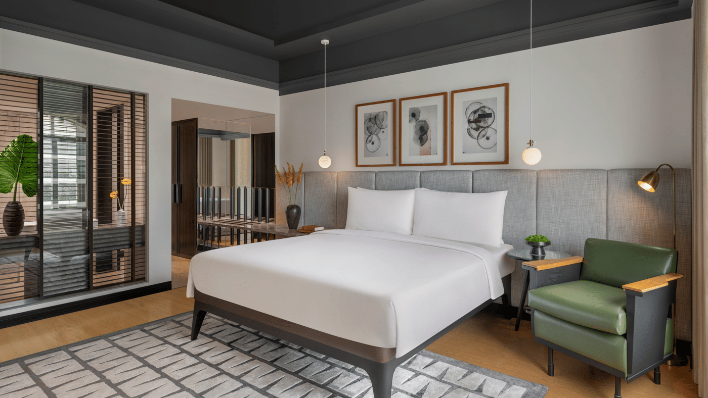 Bedroom with large bed, seating area, and windows at The Raintree, St. Mary’s Road.