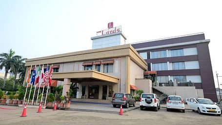 Facade of Rang Lords Inn, Bharuch, with its distinctive architecture, entrance, and parked vehicles on a bright day