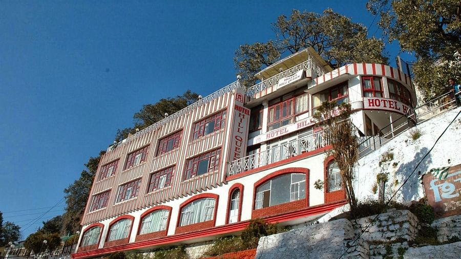 Facade of Amara Hill Queen, Mussoorie with trees in the background.