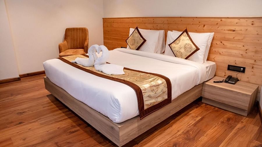 A cosy double bed with swans made of white towels kept on the bed runner in Standard Room at Sumitel Sanderling.