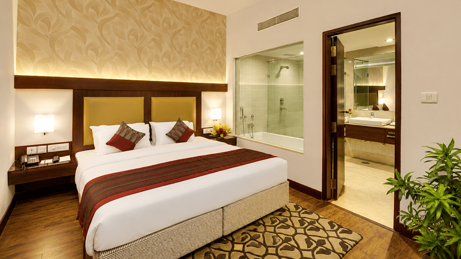 Deluxe Suite with king-size bed, bedside tables and attached bathroom.