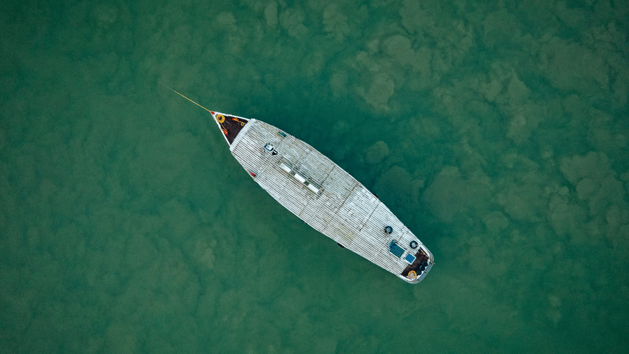 Aerial view of a boat cruising on a river.