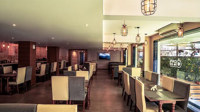 Image of M Cafe with sofa and tables at Vagator Downtown, Goa
