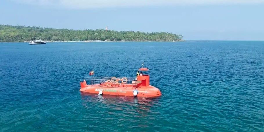 An orange bodied Semi Submarine in blue green clear waters