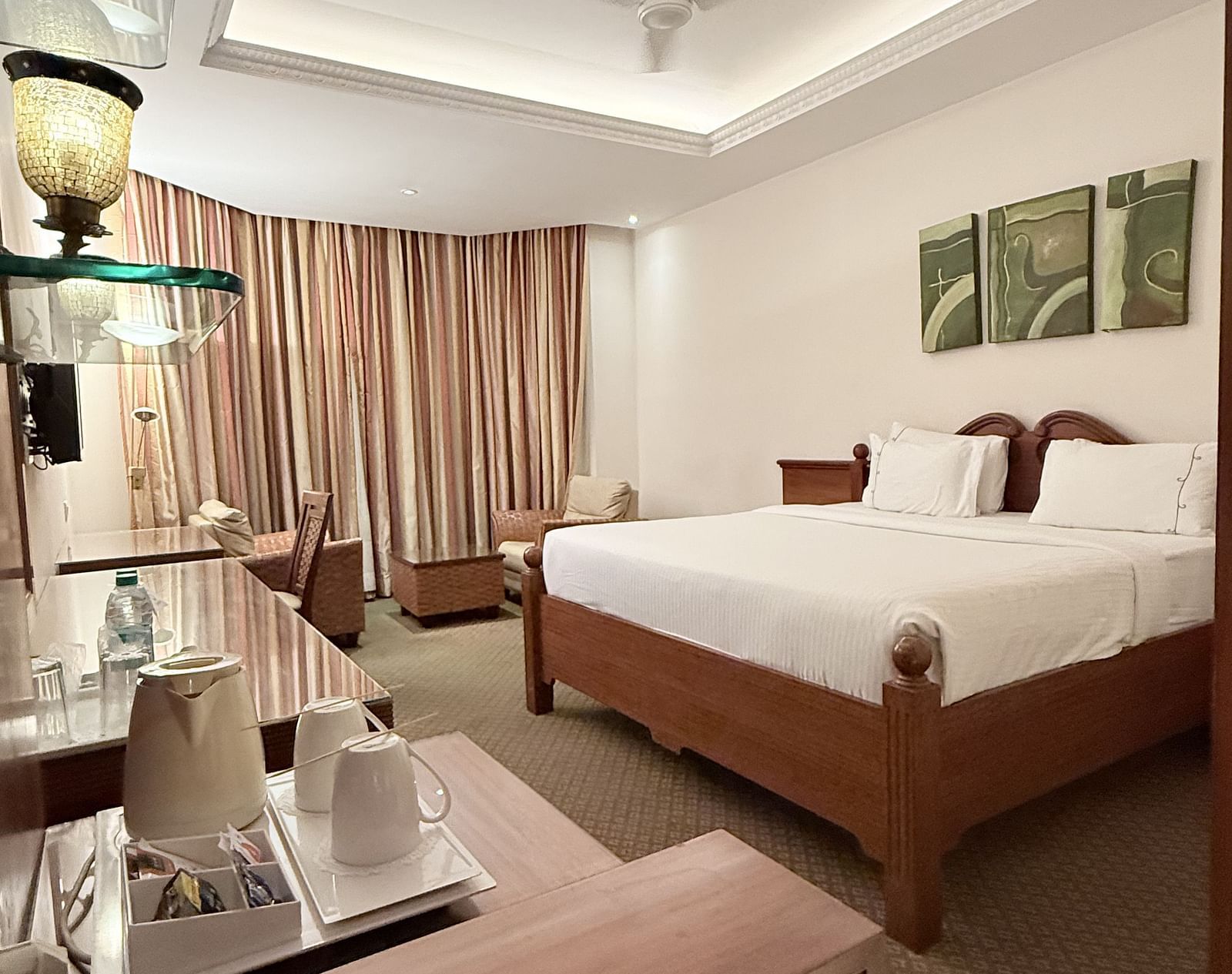 A spacious room with a large bed and a side table holding a tray of essentials | Cenneys Gateway