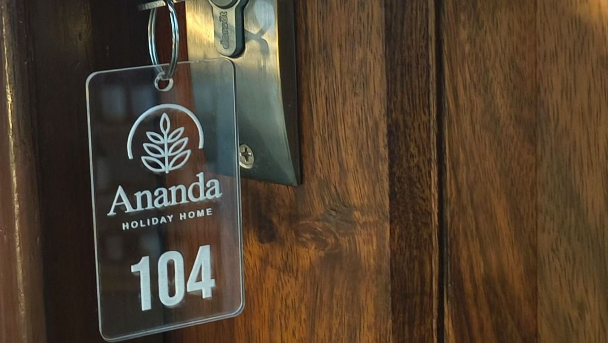 A key hanging on the door with a key chain saying  Ananda 104 room at Ananda Holiday Home, Wayanad 3