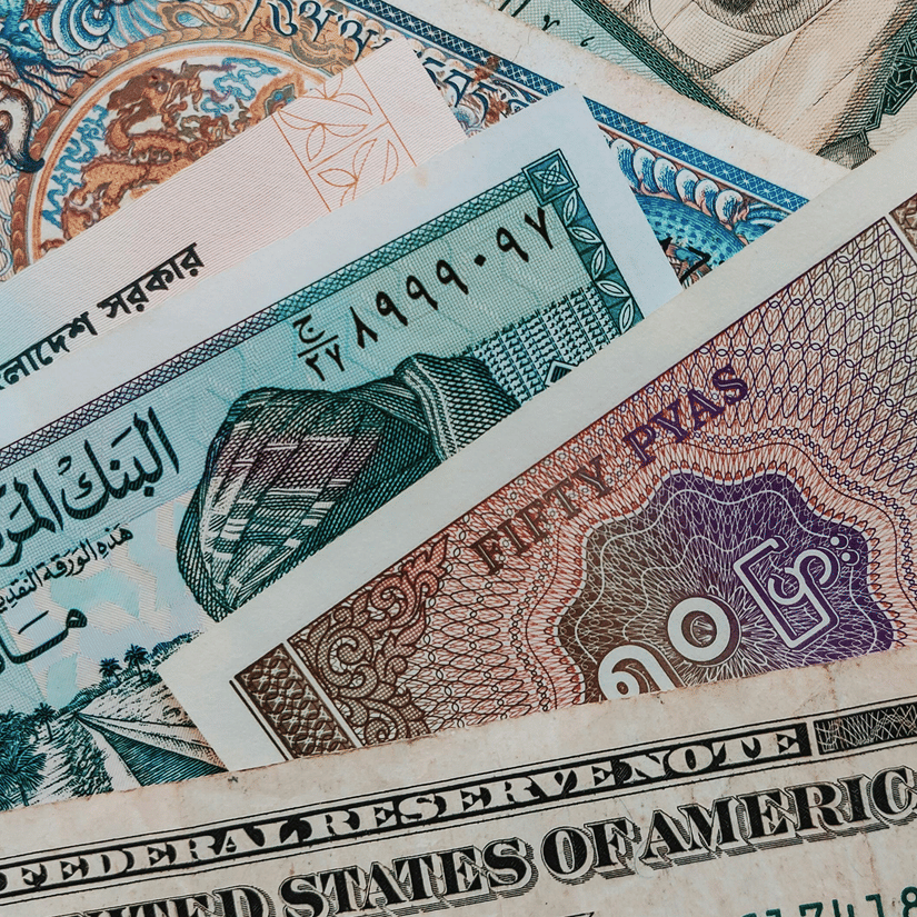 A top-down view of numerous currencies of different countries kept on top of each other.