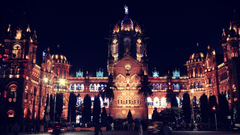 A large illuminated historic building photographed at night with towers and arches.