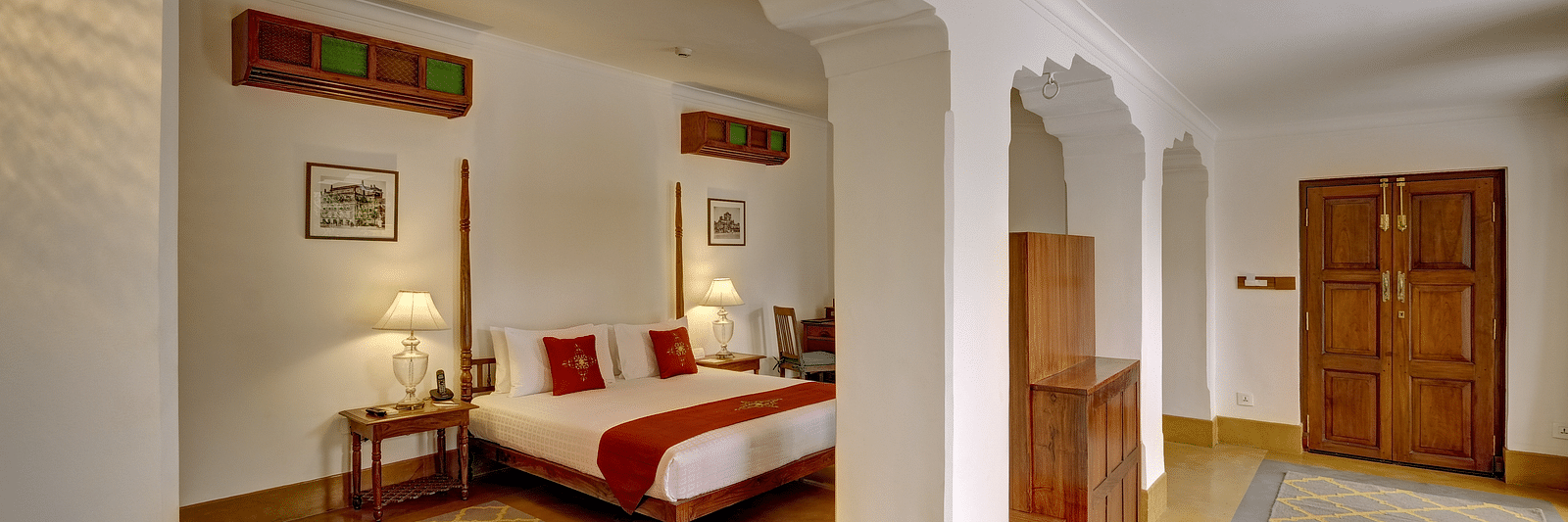 Imperial Suite at Saraca Hotel, Lucknow with a double bed and a large open living space with arched pillars