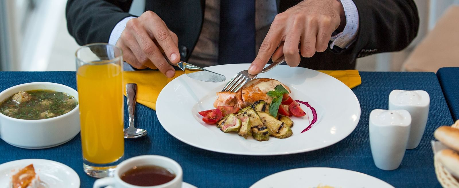 A bsinessman dining with a plate of a gourmet food, orange juice, and tea -  Sitara Luxury Hotel in Hyderabad near Ramoji Film City.