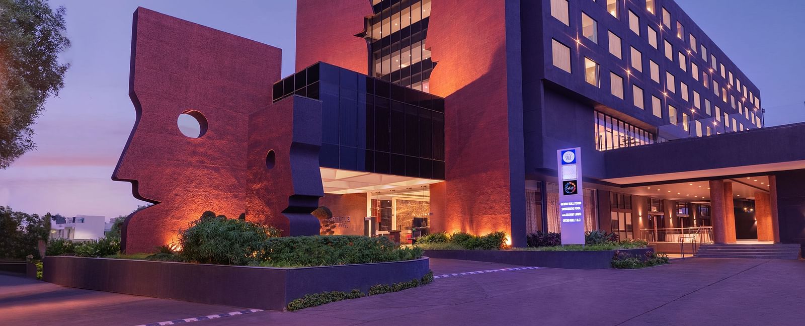 Far out view of Essentia Luxury Hotel, Indore during blue hour with the lights on.