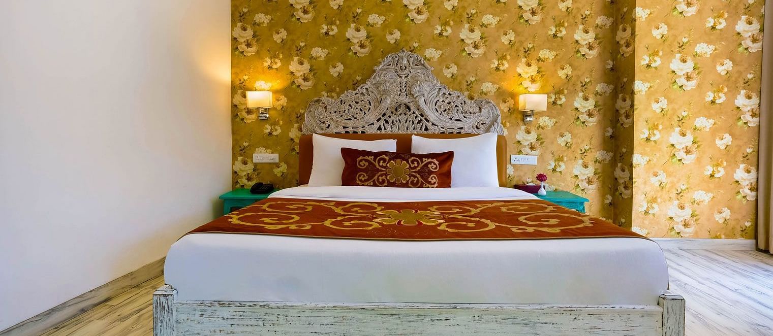 Image of a room with wooden bed and lamps on the side of the bed at Summit By The Ganges Beach Resort & Spa, Rishikesh